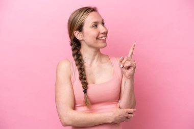 Pembe arka planda izole edilmiş beyaz bir kadın harika bir fikre işaret ediyor.