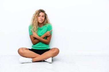 Yerde oturan kıvırcık saçlı kız yan tarafı işaret ediyor. Şüpheleri var.