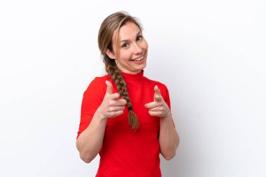 Beyaz arka planda izole edilmiş genç beyaz kadın şaşırmış ve ön tarafı işaret ediyor.