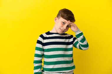 Sarı arka planda izole edilmiş küçük kızıl çocuk bir şey fark etti ve çözümü arıyor.