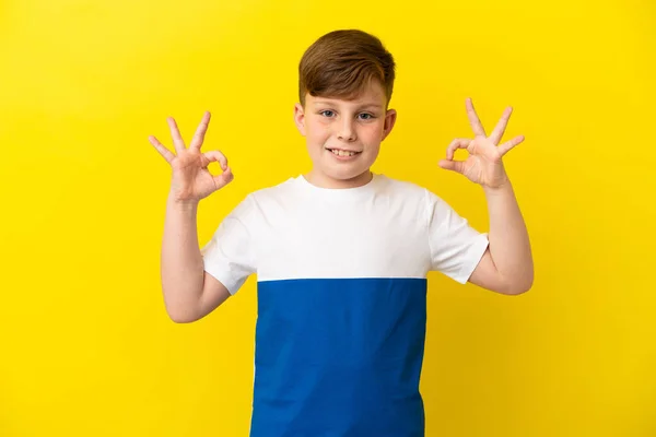 Kleine Roodharige Jongen Geïsoleerd Gele Achtergrond Tonen Teken Met Twee — Stockfoto