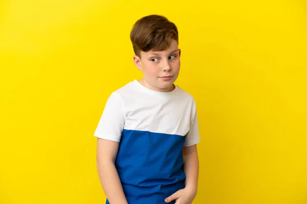 Little Redhead Boy Isolated Yellow Background Making Doubts Gesture Looking — Stock fotografie