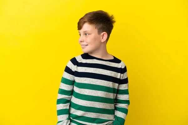 Little Redhead Boy Isolated Yellow Background Looking Side Smiling — ストック写真