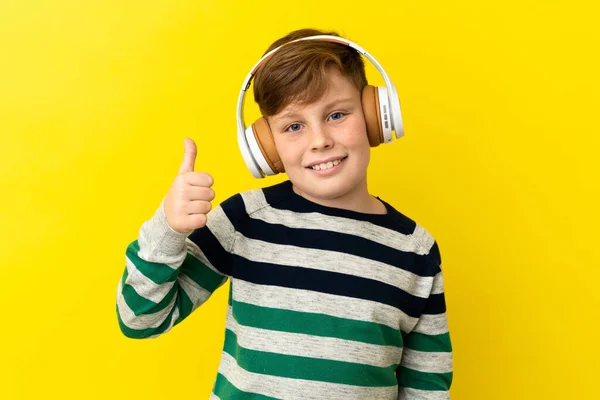 Little Redhead Boy Isolated Yellow Background Listening Music Thumb — 图库照片