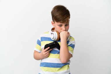 Küçük kızıl saçlı çocuk beyaz arka planda izole edilmiş bir oyun sahası tutuyor.