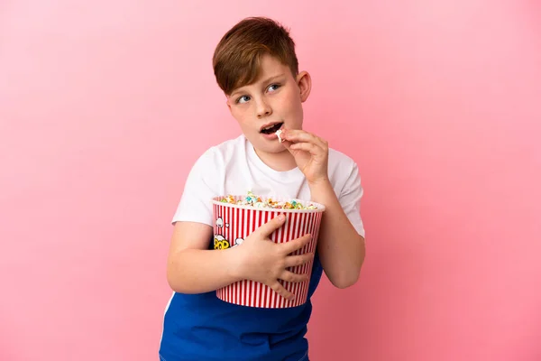 Pequeno Menino Ruivo Isolado Fundo Rosa Segurando Grande Balde Pipocas — Fotografia de Stock