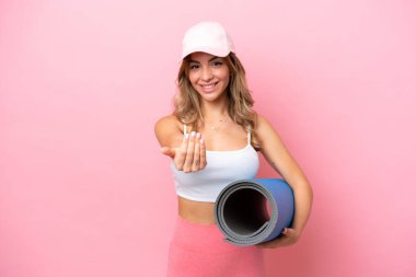 Genç sporcu kadın, elinde paspas tutarak yoga derslerine gidiyor. Gelmene sevindim.