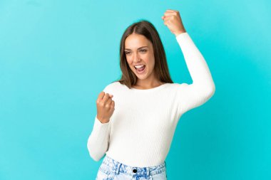 Genç bir kadın mavi arka planda zaferi kutluyor.