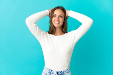 Genç bir kadın mavi arka planda gülüyor.