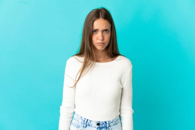 Hüzünlü ifadesiyle soyutlanmış mavi arka planı olan genç bir kadın