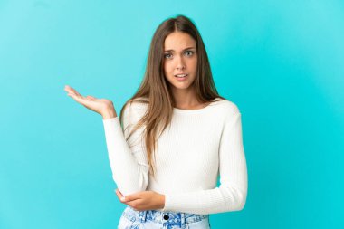 İzole edilmiş mavi arka planı olan genç bir kadın.