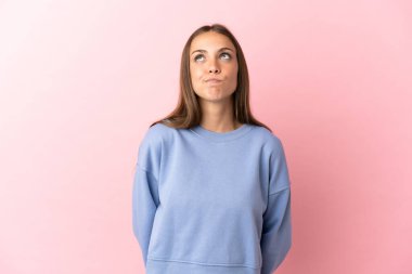 Soyutlanmış pembe arka planı olan genç bir kadın.