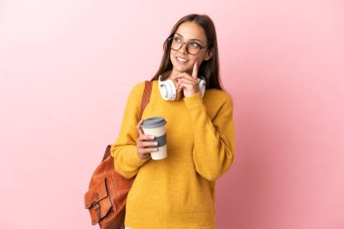 Soyutlanmış pembe arka planda genç bir bayan bir fikir ararken...