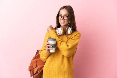 Tecrit edilmiş genç bayan öğrenci pembe arka plan zaferi kutluyor.