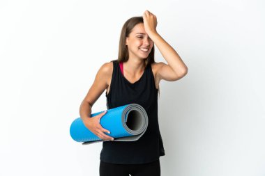 Sport woman going to yoga classes while holding a mat over isolated white background has realized something and intending the solution