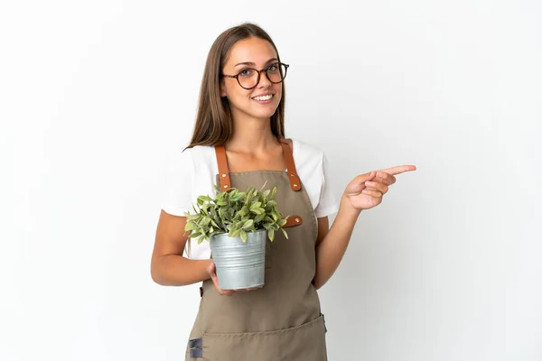 Gardener Girl Holding Plant Isolated White Background Pointing Finger Side — Stockfoto