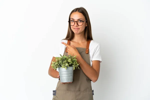 Tuinmeisje Met Een Plant Geïsoleerde Witte Achtergrond Wijzend Naar Zijkant — Stockfoto