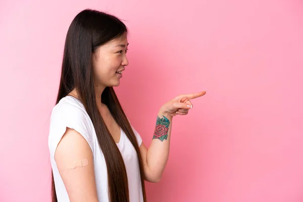 Young Chinese Woman Wearing Band Aids Isolated Pink Background Pointing — Foto Stock