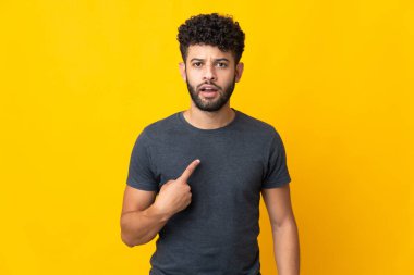 Sarı arka planda izole edilmiş genç Faslı adam kendini işaret ediyor.