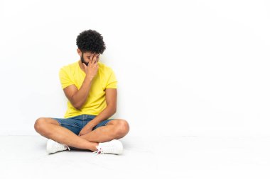 Young Moroccan handsome man sitting on the floor over isolated background laughing