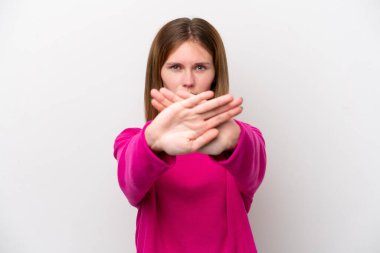 Beyaz arka planda izole edilmiş genç bir İngiliz kadın bir eylemi durdurmak için eliyle jest yapıyor.