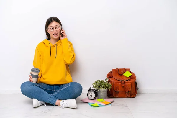 Młoda Chińska Studentka Siedzi Podłodze Odizolowana Białej Ścianie Trzymając Kawę — Zdjęcie stockowe
