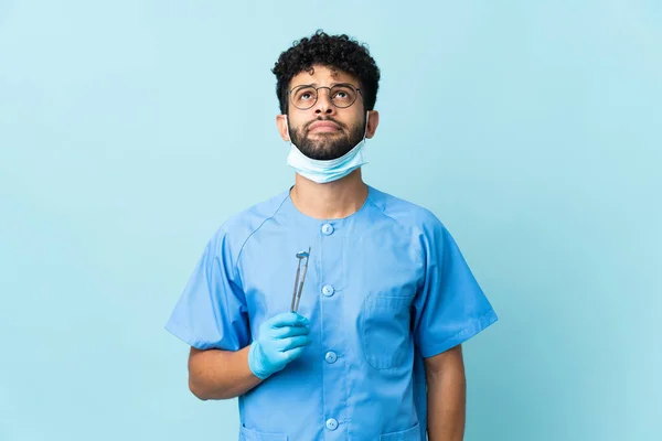 Homem Dentista Marroquino Segurando Ferramentas Isoladas Fundo Azul Olhando Para — Fotografia de Stock