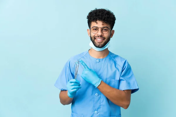 Homem Dentista Marroquino Segurando Ferramentas Isoladas Fundo Azul Apontando Para — Fotografia de Stock