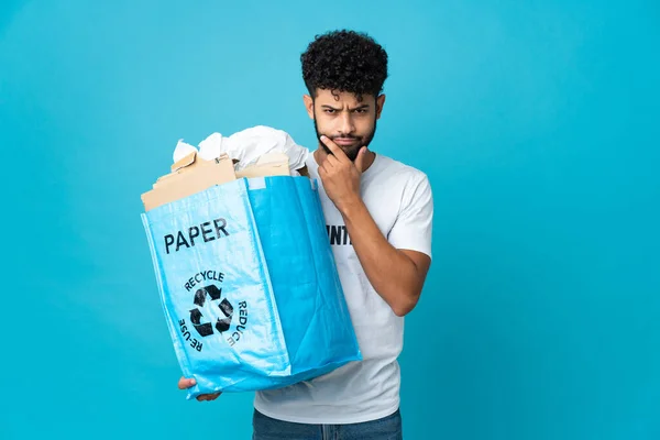 年轻的摩洛哥男子拿着一个装满纸的回收袋 通过孤立的背景思维进行回收利用 — 图库照片