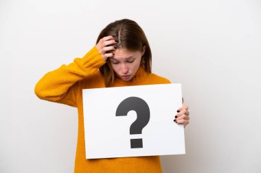 Beyaz arka planda izole edilmiş genç bir İngiliz kadın elinde soru işareti sembolü ve şaşırmış ifade içeren bir pankart tutuyor.