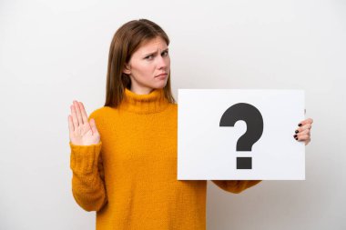 Beyaz arka planda izole edilmiş genç bir İngiliz kadın soru işareti yazılı bir pankart tutuyor ve dur işareti yapıyor.