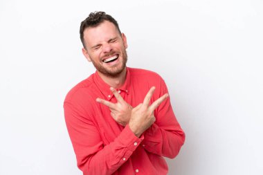 Beyaz arka planda izole edilmiş genç Brezilyalı adam gülümsüyor ve zafer işareti gösteriyor