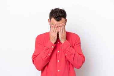 Genç Brezilyalı adam beyaz arka planda izole edilmiş, yorgun ve hasta bir ifadeyle.