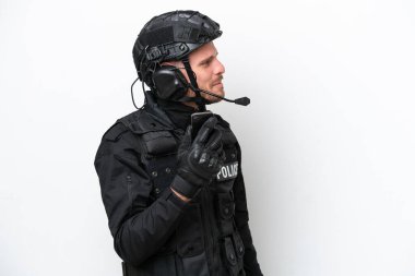Brazilian soldier man isolated on white background keeping a conversation with the mobile phone with someone