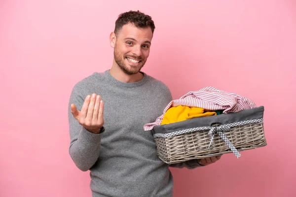 Young Brazilian Man Holding Clothes Basket Isolated Pink Background Inviting — Stockfoto