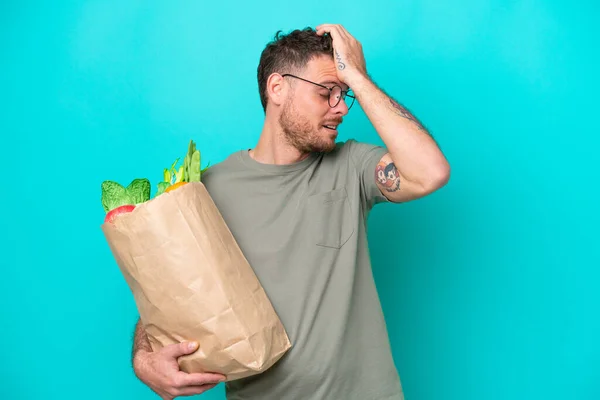 Young Brazilian Man Holding Grocery Shopping Bag Isolated Blue Background — Φωτογραφία Αρχείου