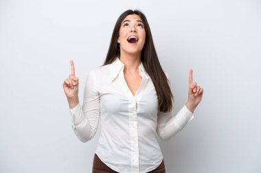 Beyaz arka planda izole edilmiş genç Brezilyalı kadın şaşırmış ve işaret ediyor.