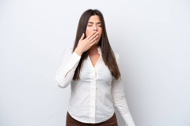 Genç Brezilyalı bir kadın beyaz arka planda izole edilmiş esniyor ve ağzını eliyle açık tutuyor.