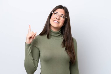 Beyaz arka planda izole edilmiş genç Brezilyalı kadın harika bir fikre işaret ediyor.