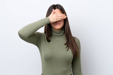 Genç Brezilyalı kadın beyaz arka planda izole edilmiş, gözleri elle kaplanmış. Bir şey görmek istemiyorum.