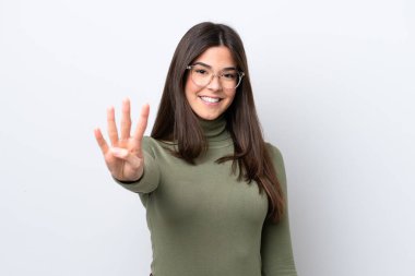 Beyaz arka planda izole edilmiş genç Brezilyalı kadın mutlu ve parmakları olan dört kişi sayıyor.