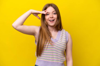 Sarı arka planda izole genç beyaz kadın bir şey fark etti ve çözüme niyetlendi.