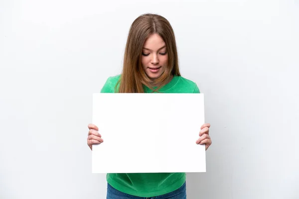 Mladá Běloška Izolovaná Bílém Pozadí Drží Prázdný Plakát Dívá Něj — Stock fotografie