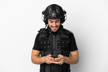 Beyaz arka planda izole genç Kafkas SWAT cep telefonu ile bir mesaj gönderiyor
