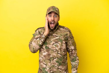 Sarı arka planda izole edilmiş, şaşırmış ve şok olmuş bir yüz ifadesi olan bir asker.