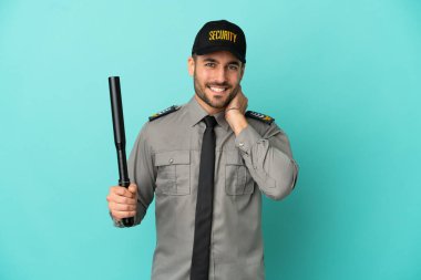 Genç güvenlik görevlisi mavi arka planda izole edilmiş gülüyor.