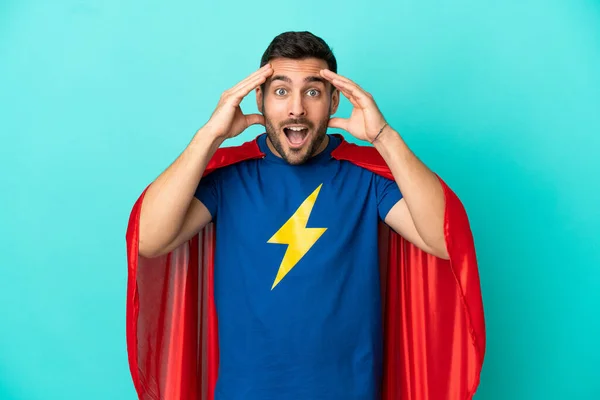 Super Hero caucasian man isolated on blue background with surprise expression
