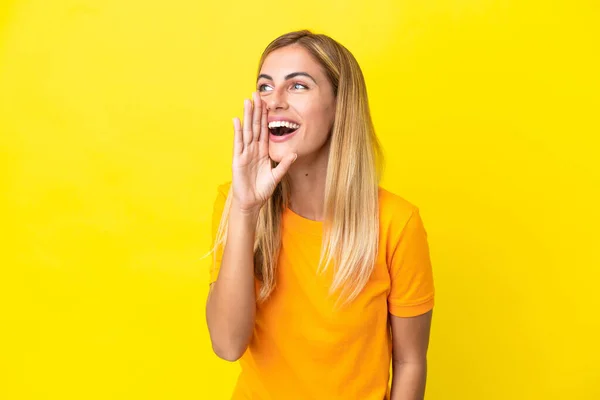 Blondynka Urugwajska Dziewczyna Odizolowana Żółtym Tle Krzyczy Szeroko Otwartymi Ustami — Zdjęcie stockowe