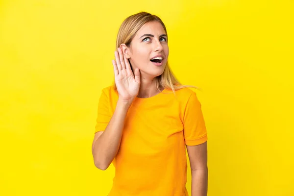 Ξανθιά Ουρουγουανή Κοπέλα Απομονωμένη Κίτρινο Φόντο Ακούγοντας Κάτι Βάζοντας Χέρι — Φωτογραφία Αρχείου