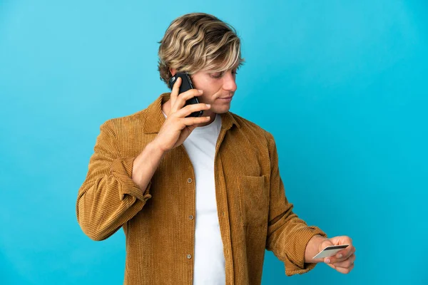 Angielski Człowiek Ponad Odizolowane Niebieskie Tło Zakupu Pomocą Telefonu Komórkowego — Zdjęcie stockowe